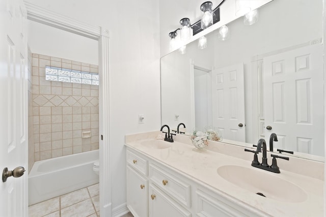 bathroom with tiled shower / bath combo, tile patterned flooring, and vanity