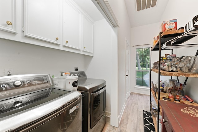 laundry area with light wood-type flooring, cabinets, and independent washer and dryer