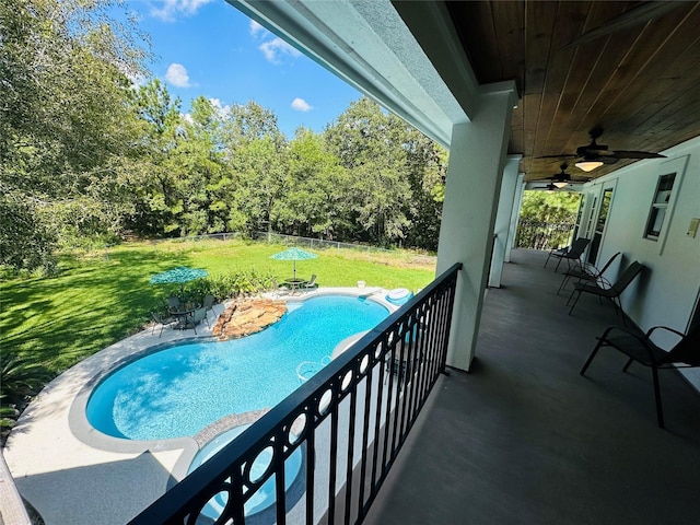 view of swimming pool featuring ceiling fan and a yard