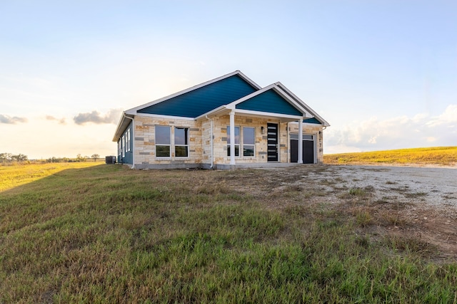 view of front of property with a garage, stone siding, and cooling unit