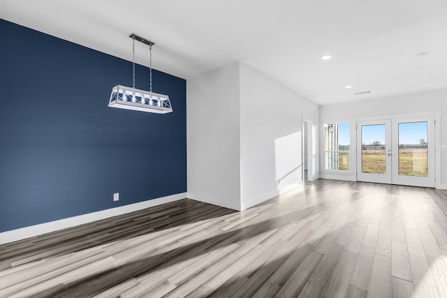 empty room with french doors, recessed lighting, visible vents, wood finished floors, and baseboards