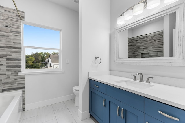 bathroom with toilet, vanity, and baseboards