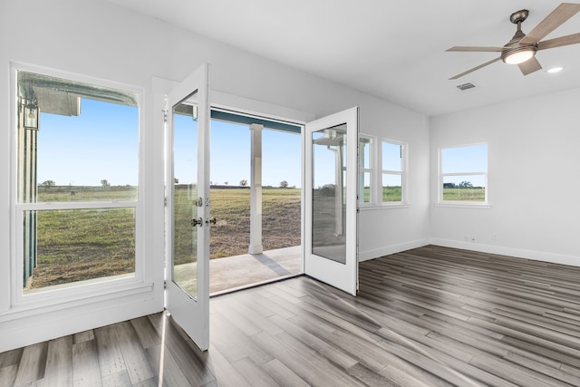 unfurnished sunroom featuring a ceiling fan and visible vents