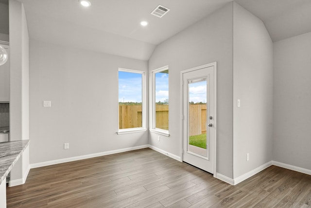 interior space with hardwood / wood-style floors and vaulted ceiling