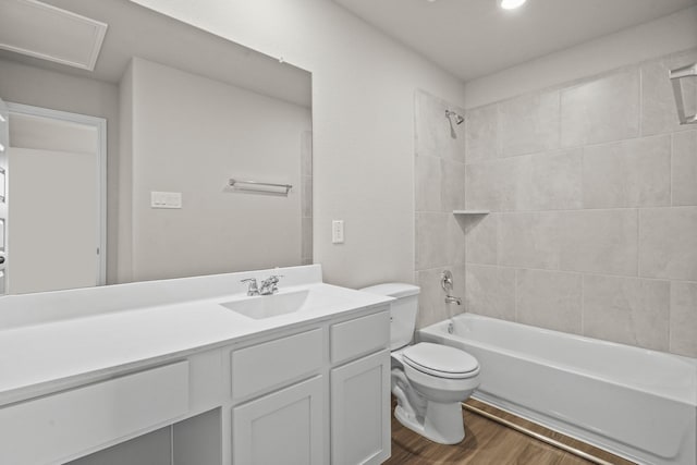 full bathroom with vanity, toilet, hardwood / wood-style floors, and tiled shower / bath combo