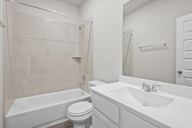 full bathroom with hardwood / wood-style flooring, toilet, vanity, and tiled shower / bath