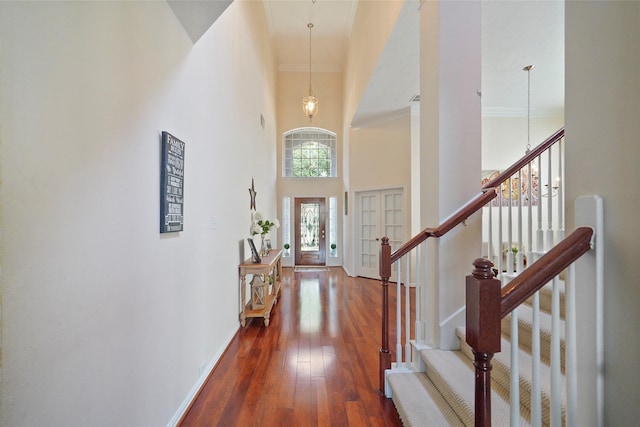 entryway with crown molding, dark hardwood / wood-style floors, and a high ceiling