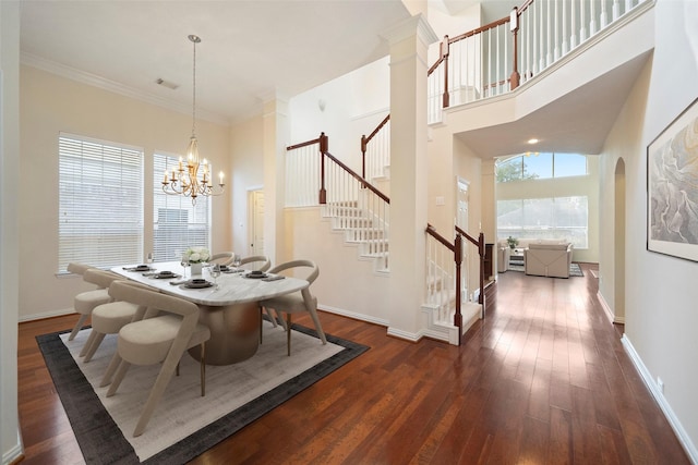 dining area with crown molding, a towering ceiling, a chandelier, and dark hardwood / wood-style floors