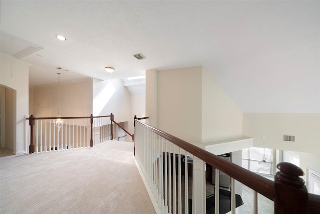 hall with lofted ceiling, light carpet, and a chandelier