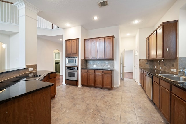 kitchen featuring sink, stainless steel appliances, washer / dryer, and tasteful backsplash