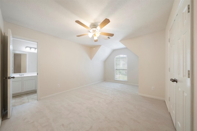 additional living space featuring ceiling fan, light colored carpet, and lofted ceiling