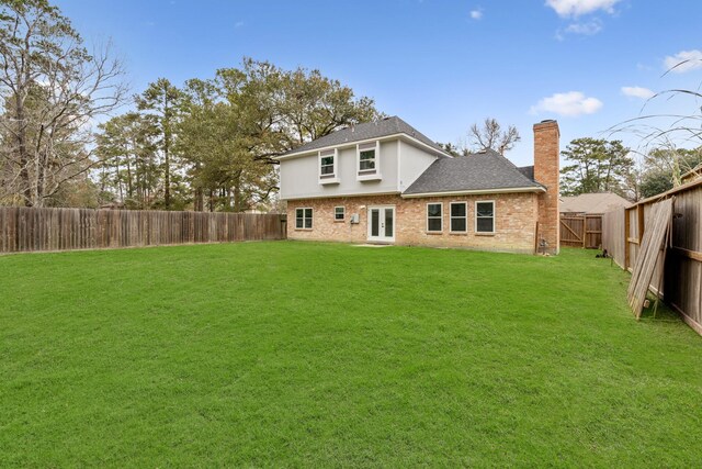 rear view of property featuring a yard