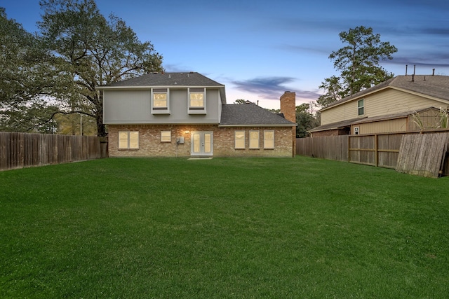 back house at dusk with a yard