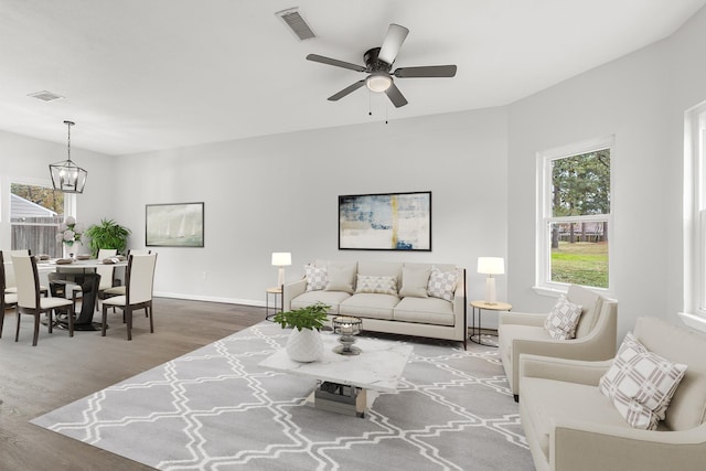 living room with hardwood / wood-style flooring and ceiling fan with notable chandelier