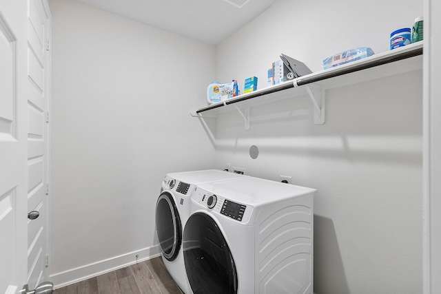 washroom with dark wood-type flooring and washer and dryer