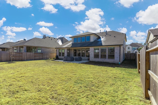 rear view of property featuring a yard and a patio area