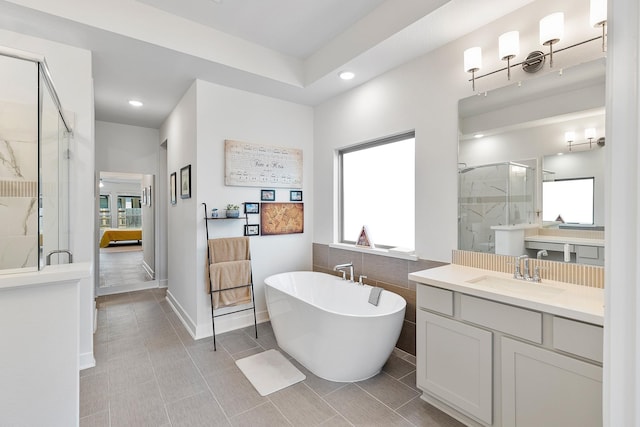 bathroom with tile patterned flooring, vanity, and separate shower and tub