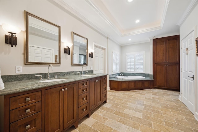 bathroom with vanity, a raised ceiling, crown molding, and a tub