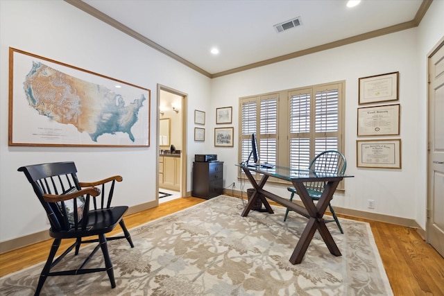 office with light hardwood / wood-style floors and ornamental molding