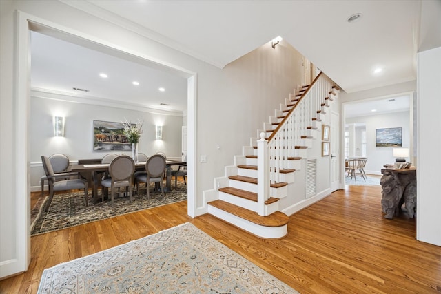 stairway featuring hardwood / wood-style flooring and ornamental molding