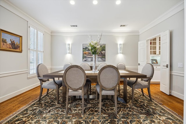 dining space with crown molding and wood-type flooring