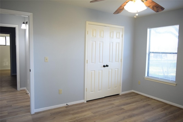 unfurnished bedroom featuring hardwood / wood-style flooring, a closet, and ceiling fan