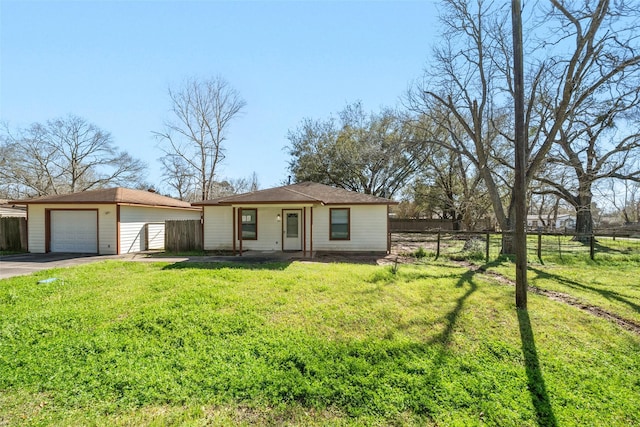 view of front of house featuring aphalt driveway, an outbuilding, a detached garage, a front yard, and fence