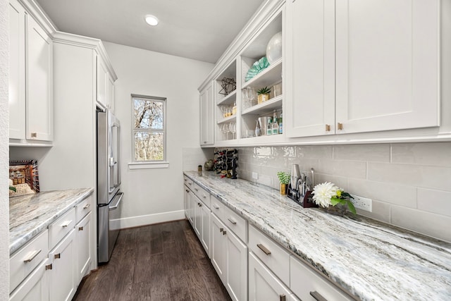 kitchen featuring light stone counters, white cabinetry, and high end refrigerator