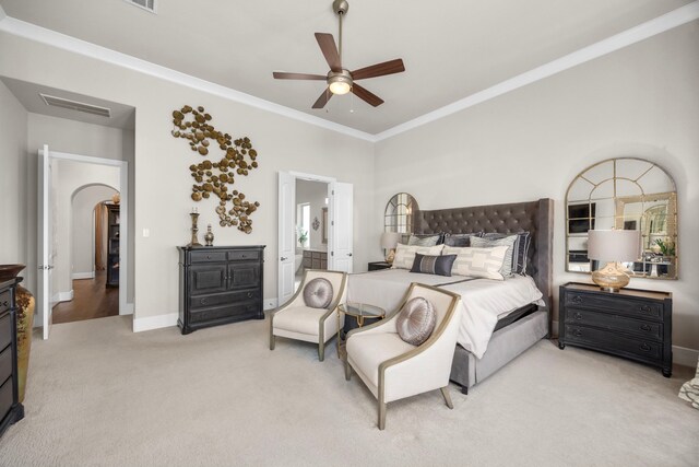 carpeted bedroom featuring ensuite bath, ornamental molding, and ceiling fan