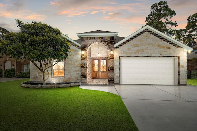 view of front of home with a garage and a lawn