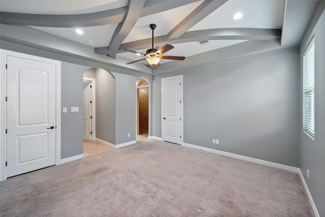 unfurnished bedroom with ceiling fan, light carpet, and beam ceiling