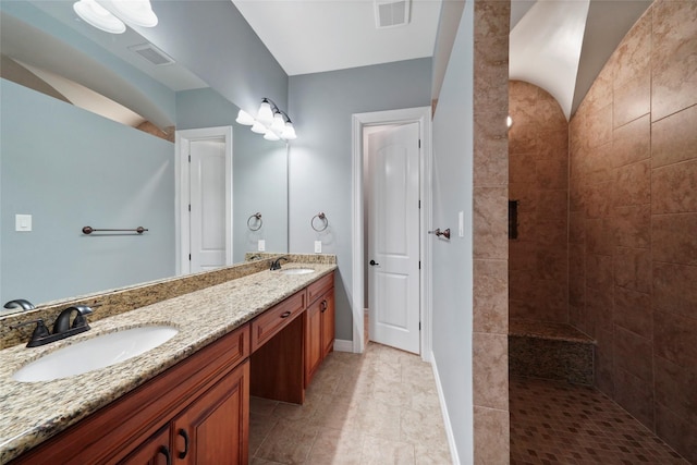 bathroom with vanity, vaulted ceiling, and a shower