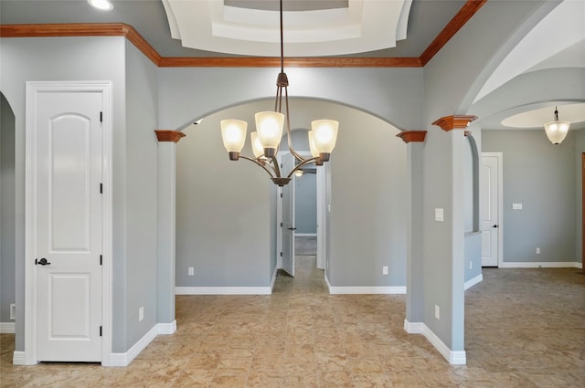 unfurnished dining area with crown molding, a tray ceiling, and decorative columns