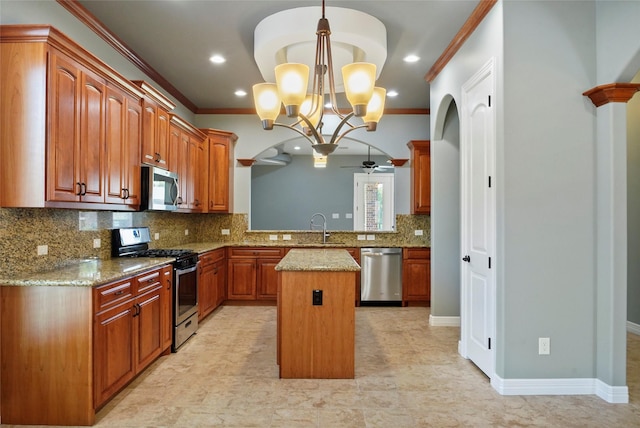 kitchen with crown molding, light stone counters, a center island, appliances with stainless steel finishes, and kitchen peninsula