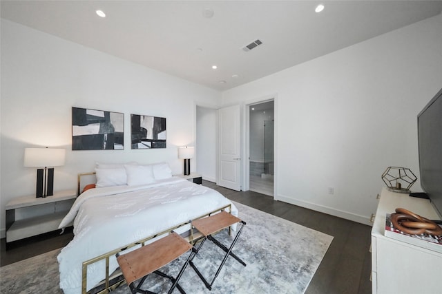 bedroom featuring connected bathroom and dark hardwood / wood-style flooring