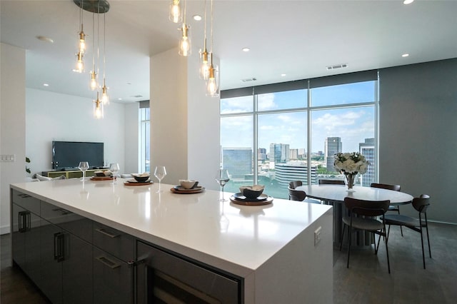 kitchen featuring a wall of windows, decorative light fixtures, and a large island