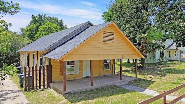 bungalow-style home with central AC unit and a front yard