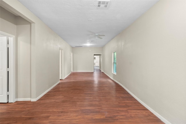 corridor featuring dark hardwood / wood-style floors and a textured ceiling