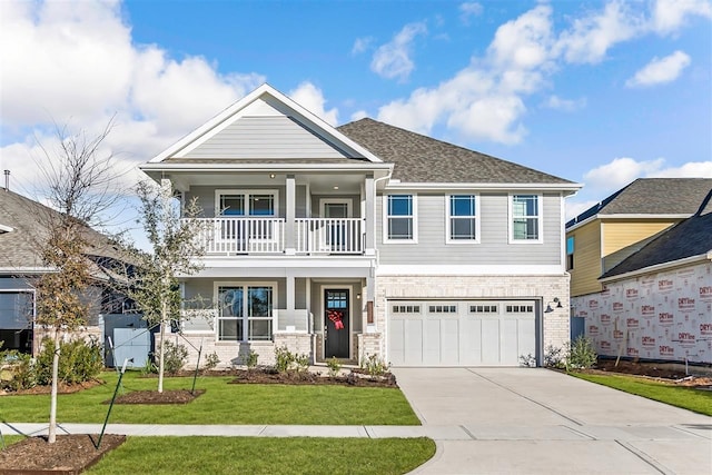 craftsman house with a balcony, a garage, and a front yard