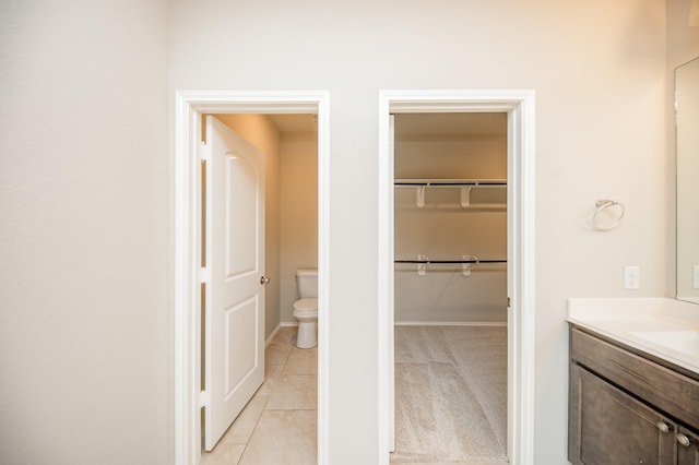 bathroom featuring toilet, vanity, and tile patterned flooring