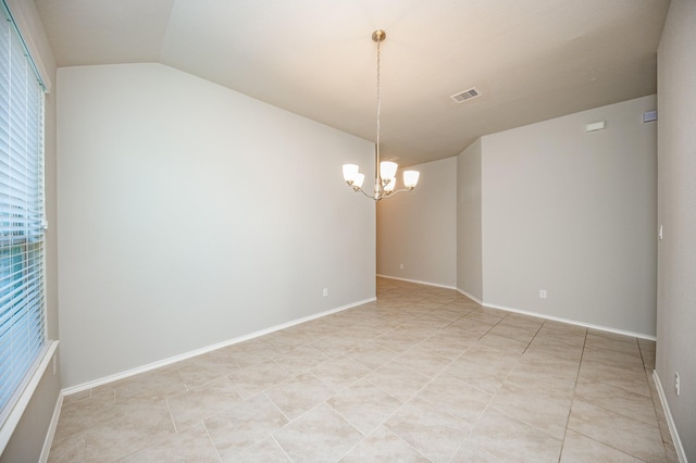 tiled empty room with a notable chandelier, a healthy amount of sunlight, and lofted ceiling