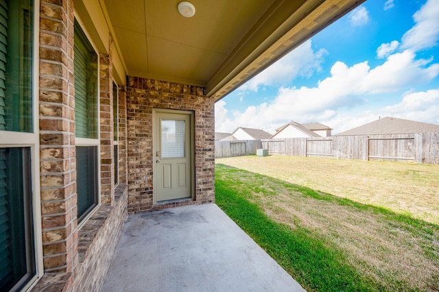 entrance to property with a patio and a lawn