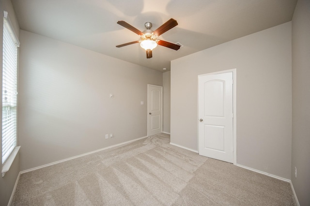 empty room featuring light colored carpet and ceiling fan