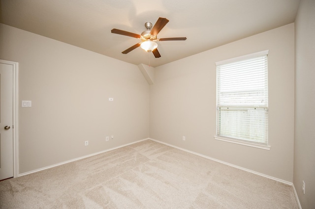 empty room with ceiling fan and light carpet