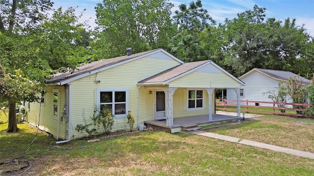 bungalow-style home with covered porch and a front lawn