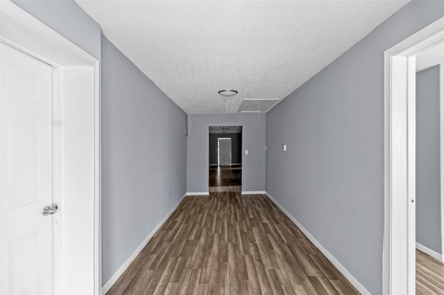 hall with dark wood-type flooring and a textured ceiling