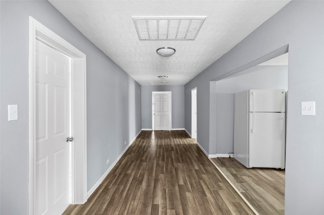 corridor with hardwood / wood-style floors and a textured ceiling