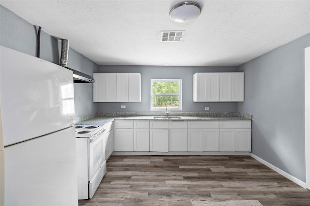 kitchen featuring sink, white cabinetry, hardwood / wood-style floors, white appliances, and wall chimney range hood