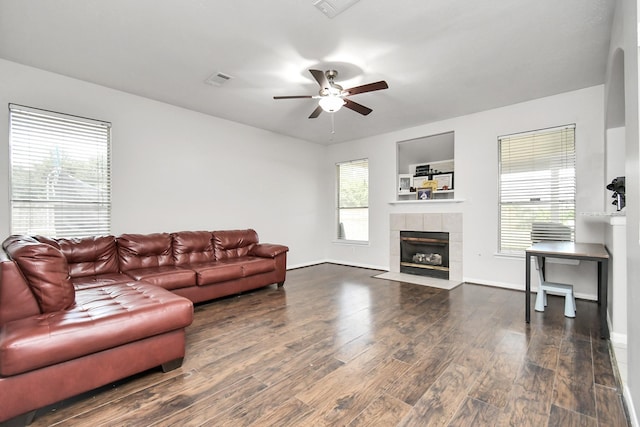 living room with a wealth of natural light, dark wood-type flooring, and a fireplace