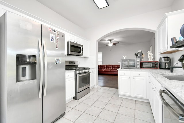 kitchen featuring ceiling fan, appliances with stainless steel finishes, sink, white cabinets, and light tile patterned flooring